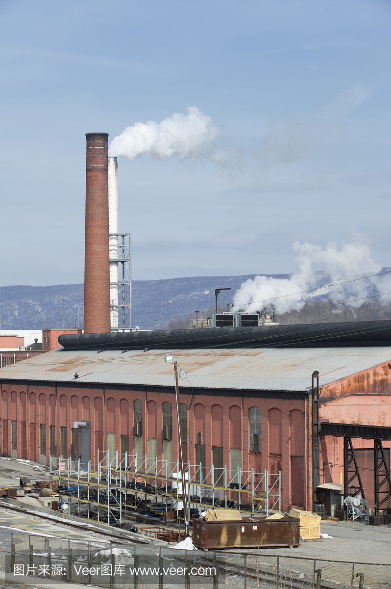 在陽光下工作的工廠與煙囪排氣